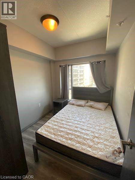 Bedroom featuring wood finished floors - 275 Larch Street Unit# F313, Waterloo, ON - Indoor Photo Showing Bedroom