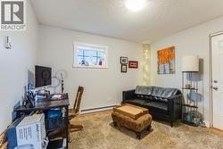 Den space with access to the covered side patio on the upper level -