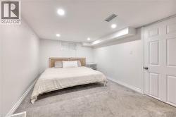 Carpeted bedroom with baseboards and recessed lighting -