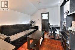 Living room featuring dark wood-style flooring, a desk, and vaulted ceiling -