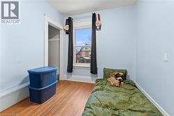 Bedroom featuring wood finished floors and baseboards -