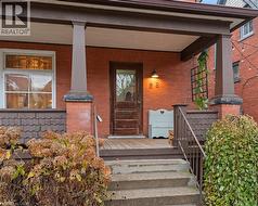 Property entrance featuring a porch and brick siding -