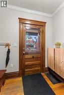Entryway with crown molding and hardwood / wood-style flooring -