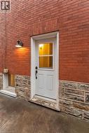 Property entrance with stone siding and brick siding -