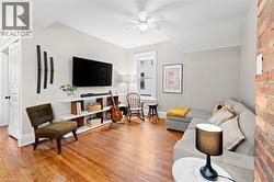 Living room with light wood-type flooring and a ceiling fan -