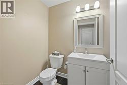 Half bath featuring vanity and dark tile patterned floors -