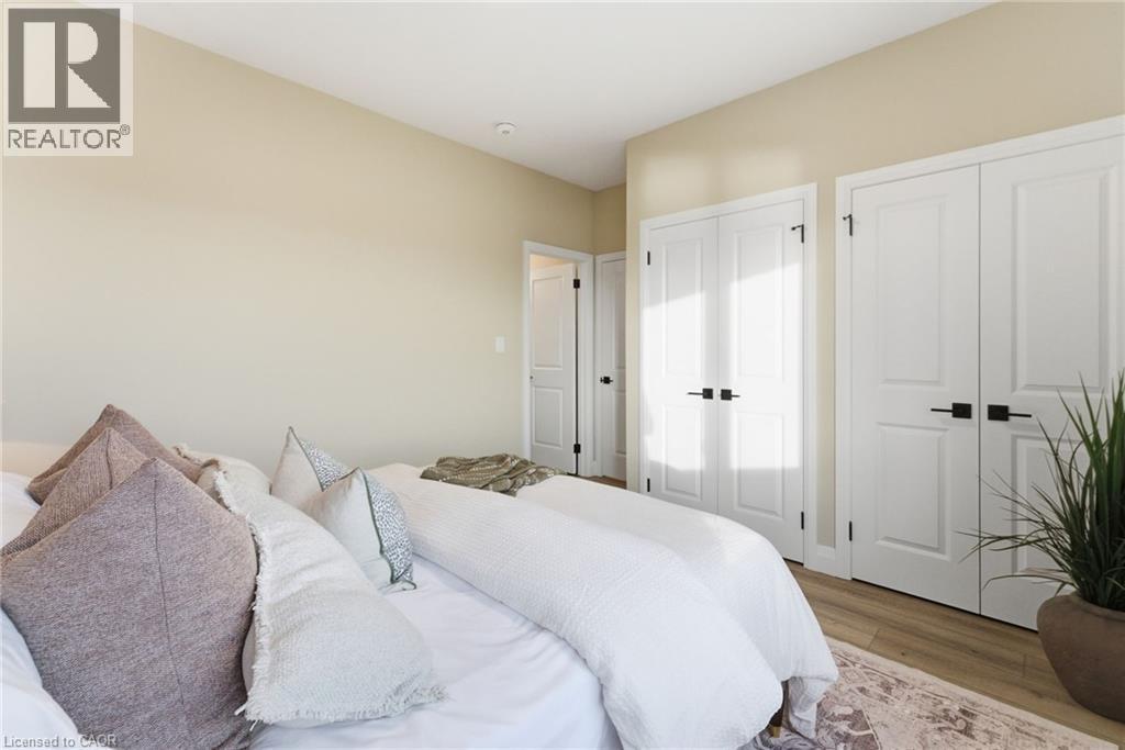 Bedroom featuring wood finished floors and two closets - 29 Weymouth Street Unit# 25, Elmira, ON - Indoor Photo Showing Bedroom
