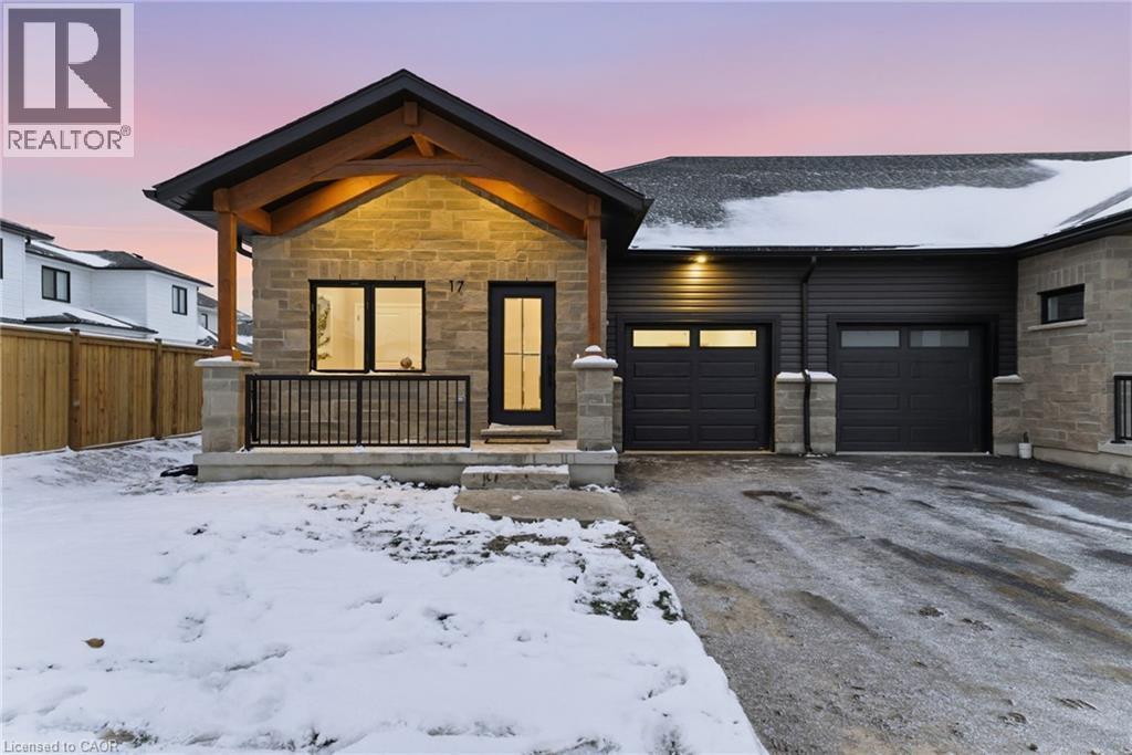 View of front of property featuring stone siding, covered porch, driveway, and a garage - 29 Weymouth Street Unit# 17, Elmira, ON - Outdoor