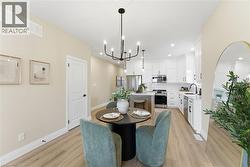 Dining area with light wood finished floors, a chandelier, and recessed lighting -