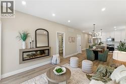 Living area with recessed lighting, a glass covered fireplace, light wood-style floors, and a chandelier -