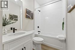 Bathroom with vanity, light wood-style flooring, and shower / bathtub combination -