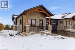 View of front of property with stone siding and a porch -