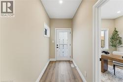Doorway with baseboards and wood finished floors -