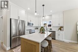 Kitchen featuring stainless steel appliances, white cabinetry, a kitchen island, and recessed lighting -
