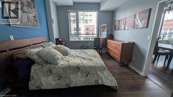 Bedroom featuring dark wood-style floors and multiple windows -