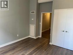 Unfurnished bedroom with dark wood finished floors and a closet -