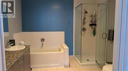 Full bath featuring light tile patterned flooring, a bath, a shower stall, and vanity -
