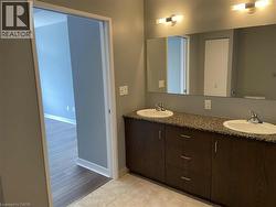 Bathroom featuring double vanity and light tile patterned floors -