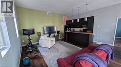 Living area featuring dark wood-type flooring and baseboards -