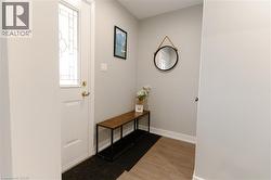 Doorway to outside featuring baseboards and wood finished floors -