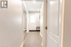 Hallway with light wood finished floors and baseboards -