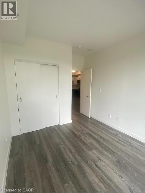 Unfurnished bedroom with dark wood-type flooring and a closet - 128 King Street Unit# 507, Waterloo, ON - Indoor Photo Showing Other Room