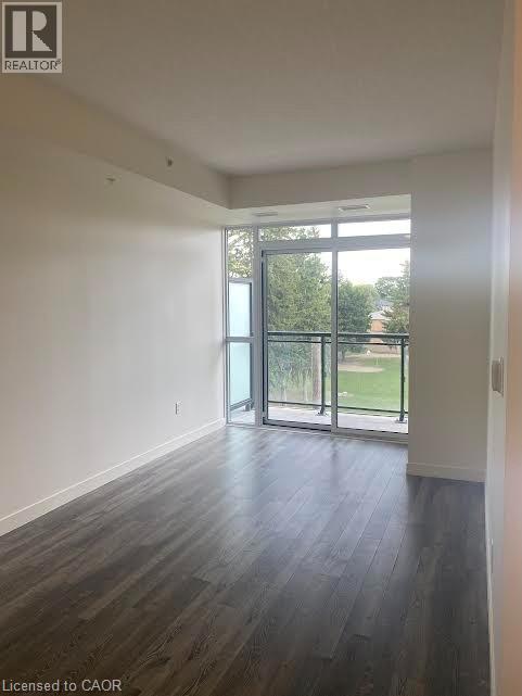 Spare room featuring dark wood-style flooring and plenty of natural light - 128 King Street Unit# 507, Waterloo, ON - Indoor