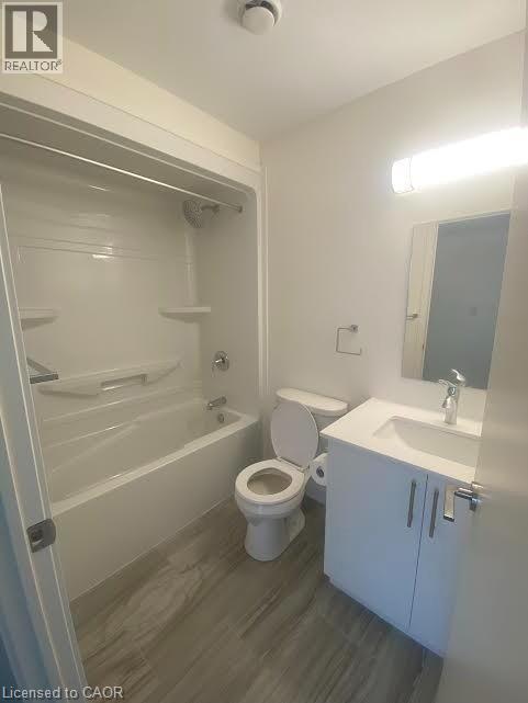 Bathroom with vanity, shower / bath combination, and dark wood-style floors - 128 King Street Unit# 507, Waterloo, ON - Indoor Photo Showing Bathroom