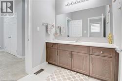 Bathroom with vanity, light carpet, and light tile patterned floors -