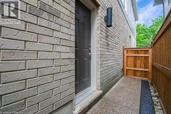 View of exterior entry featuring brick siding -