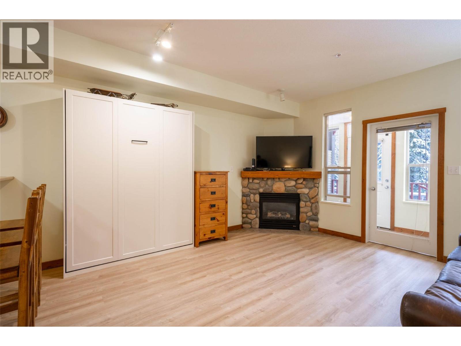 Living room (murphy bed is up) - 9812 Silver Star Road Unit# 103, Vernon, BC - Indoor Photo Showing Living Room With Fireplace
