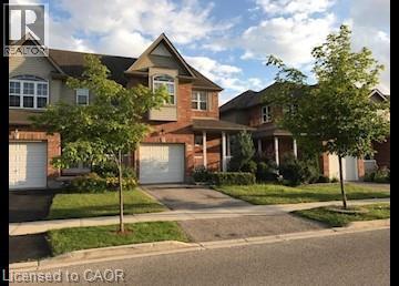 View of front facade with driveway, a garage, brick siding, and a front lawn - 567 Chablis Drive, Waterloo, ON - Outdoor With Facade