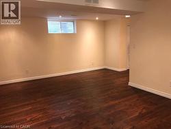 Basement with dark wood-type flooring and recessed lighting -