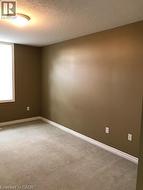 Unfurnished room with a textured ceiling and light carpet -