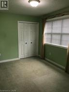 Unfurnished bedroom featuring a textured ceiling, carpet, and a closet -