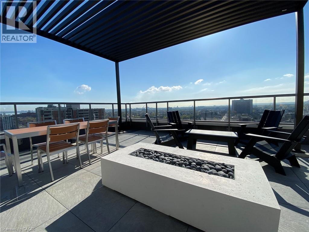 View of patio / terrace featuring a city view, an outdoor fire pit, outdoor dining space, and a pergola - 212 King William Street Unit# 1010, Hamilton, ON - Outdoor With View With Exterior