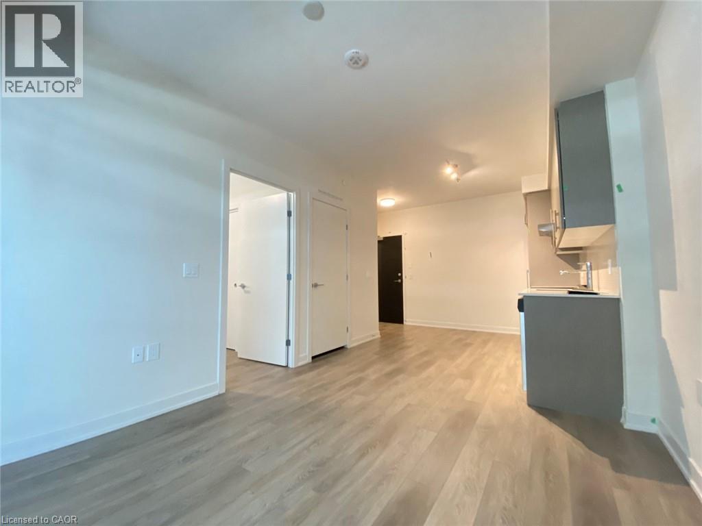 Living area with light wood-style flooring and baseboards - 212 King William Street Unit# 1010, Hamilton, ON - Indoor