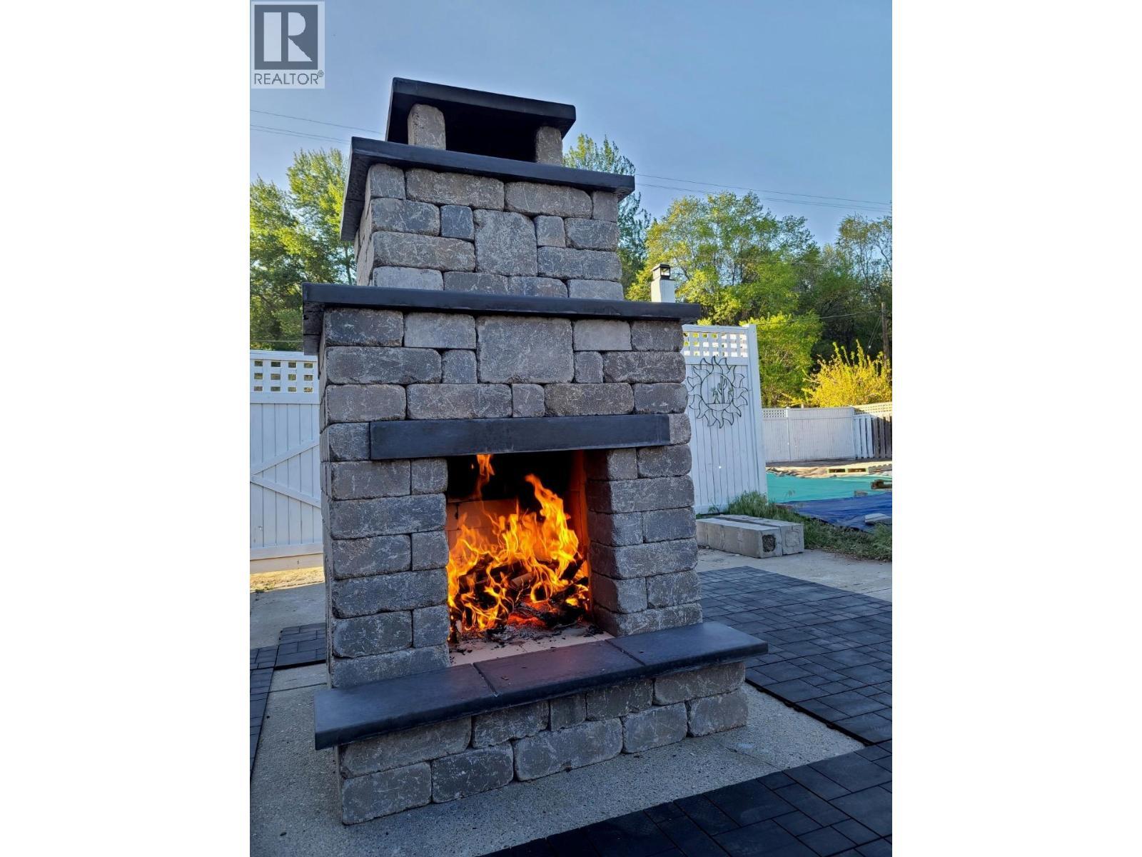 outdoor fireplace - 225 Circle Drive, Oliver, BC - With Fireplace