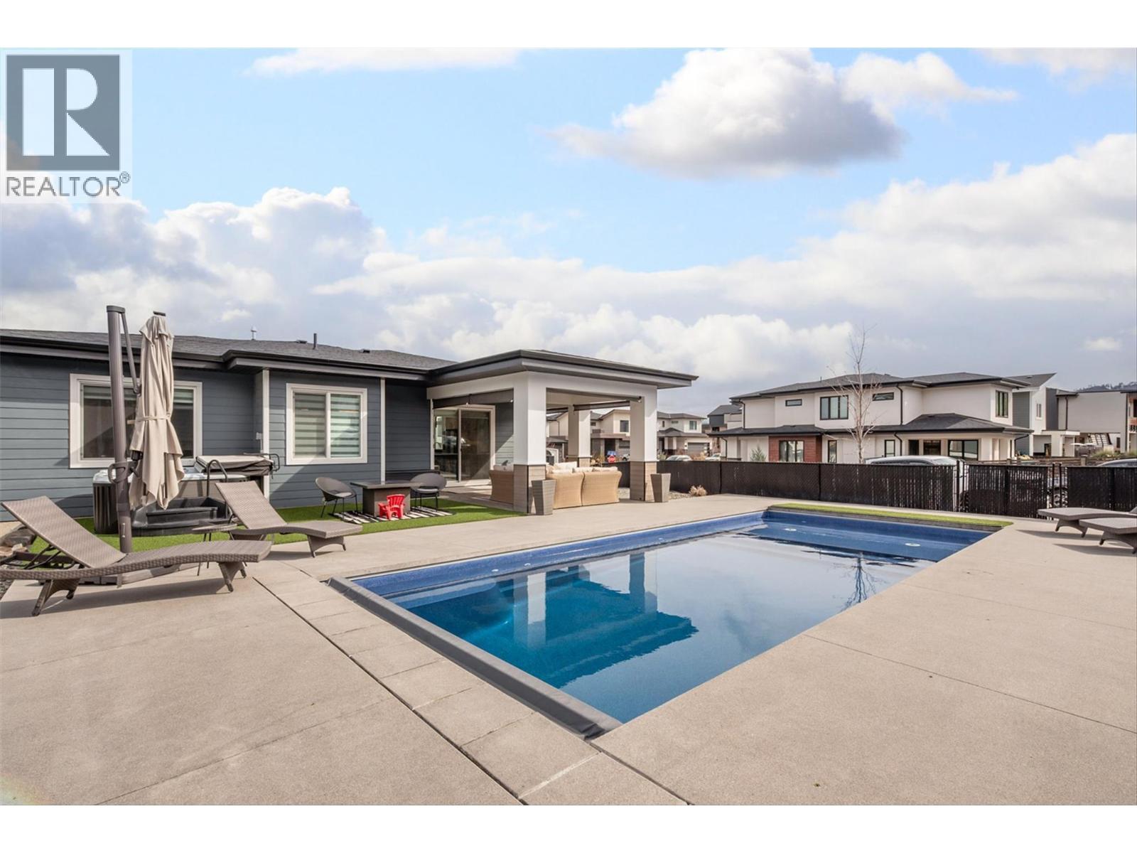 UPPER MISSION AT IT'S FINEST! Salt Water Pool with retractable cover & Hot Tub in your low maintenance yard! - 1235 Ponds Avenue, Kelowna, BC - Outdoor With In Ground Pool