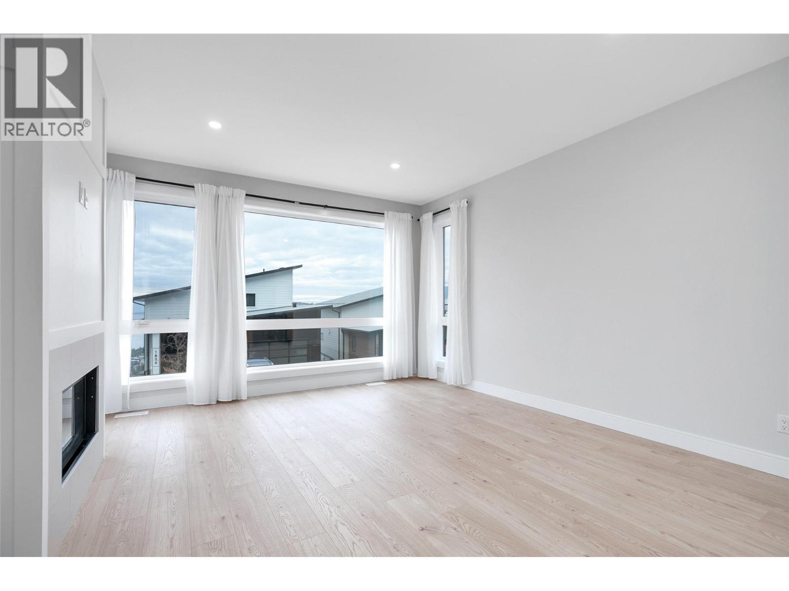 Living room - 1839 Grey Owl Court, Kelowna, BC - Indoor With Fireplace
