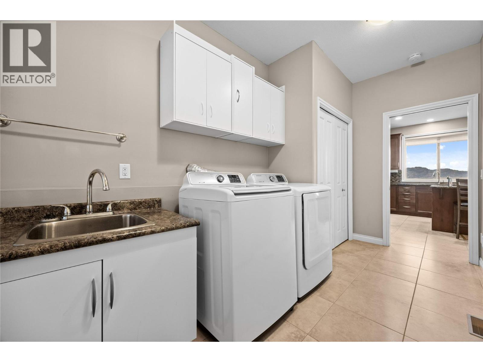 Laundry room with cabinets and sink - 5165 Trepanier Bench Road Unit# 250, Peachland, BC - Indoor Photo Showing Laundry Room