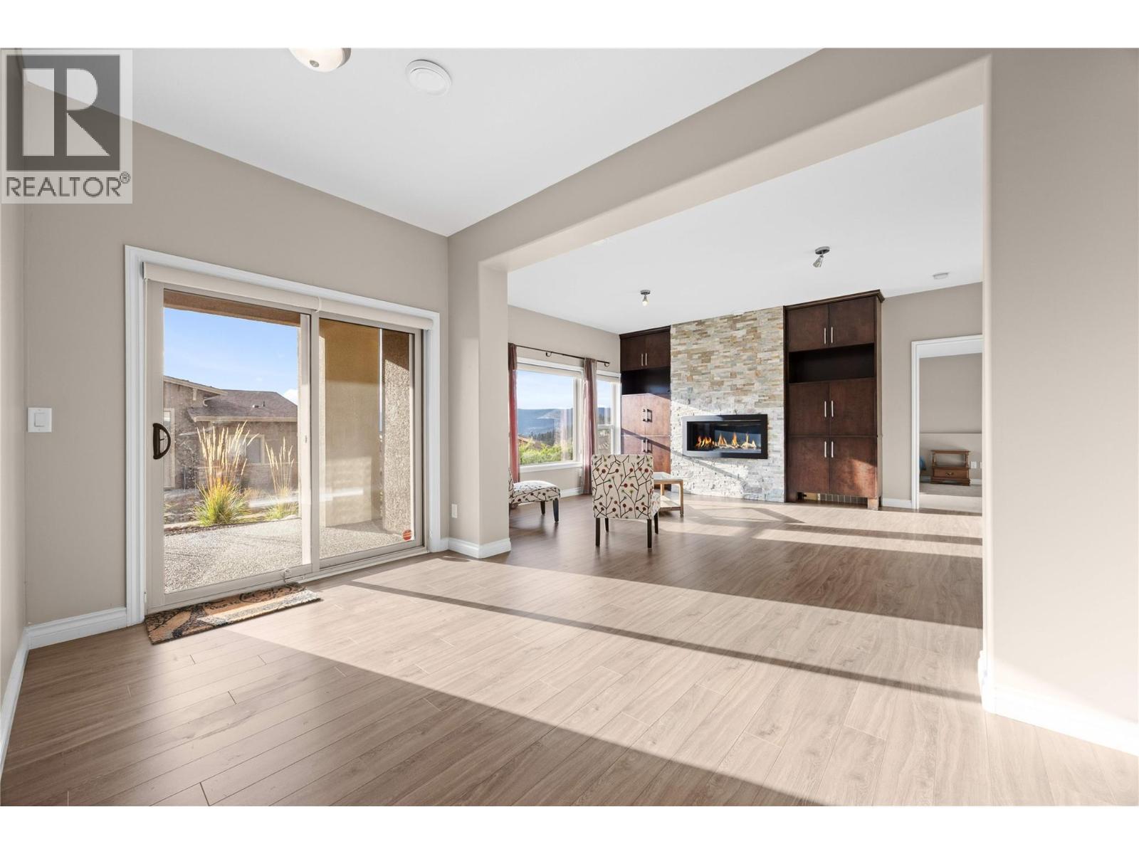 Rec / family room on lower level with access to covered patio - 5165 Trepanier Bench Road Unit# 250, Peachland, BC - Indoor Photo Showing Other Room With Fireplace