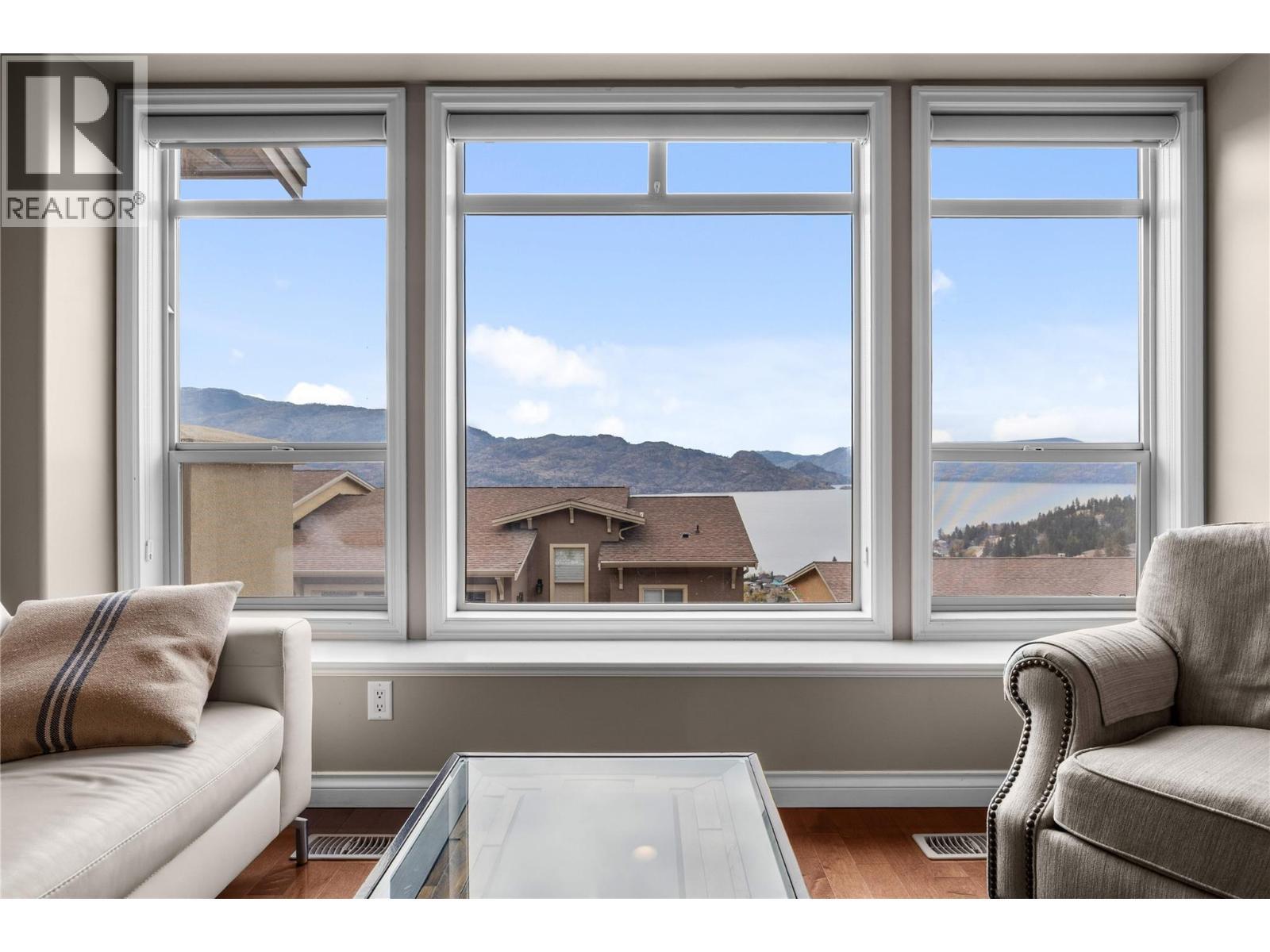 Large windows to showcase the lake and mountain views - 5165 Trepanier Bench Road Unit# 250, Peachland, BC - Indoor Photo Showing Living Room