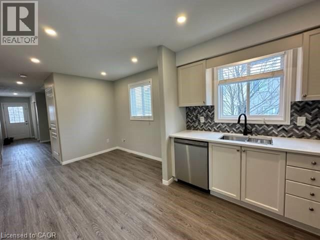 Kitchen featuring dishwasher, healthy amount of natural light, dark wood-style floors, white cabinets, and recessed lighting - 750 Paris Boulevard Unit# 1, Waterloo, ON - Indoor Photo Showing Kitchen