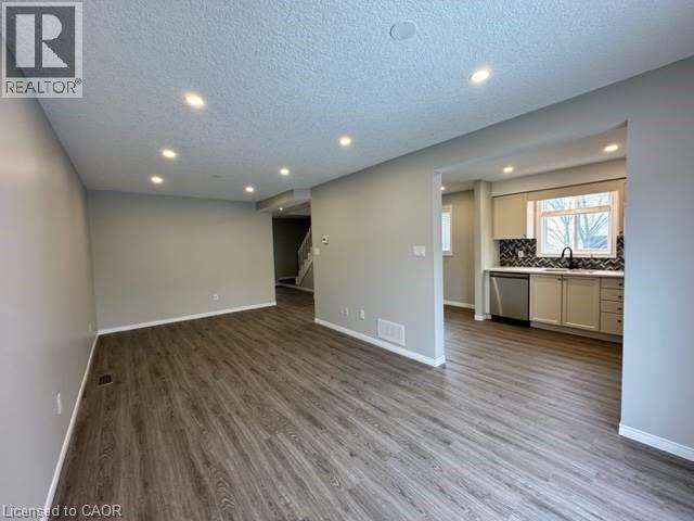 Unfurnished living room featuring recessed lighting, a textured ceiling, and dark wood finished floors - 750 Paris Boulevard Unit# 1, Waterloo, ON - Indoor