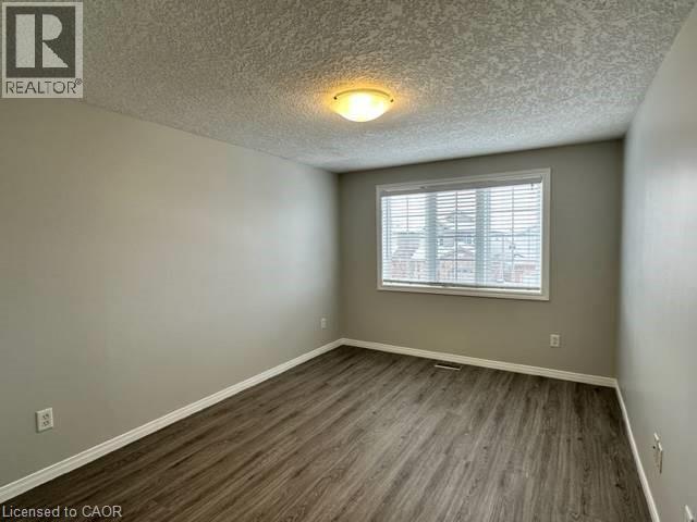 Spare room featuring dark wood finished floors and a textured ceiling - 750 Paris Boulevard Unit# 1, Waterloo, ON - Indoor Photo Showing Other Room