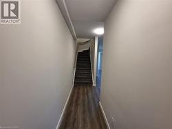 Hall with dark wood-style flooring and stairs -