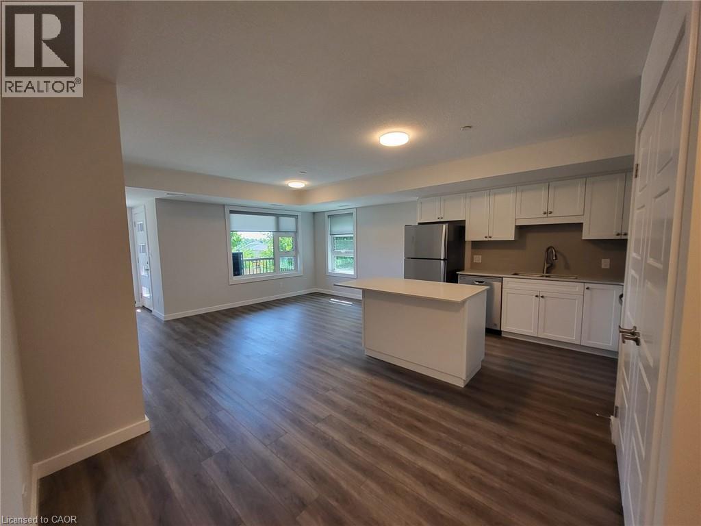 Kitchen featuring white cabinetry, a center island, light countertops, stainless steel appliances, and open floor plan - 118 Gravel Ridge Trail Unit# D16, Kitchener, ON - Indoor Photo Showing Kitchen