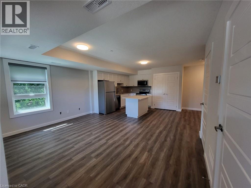 Kitchen with open floor plan, white cabinets, light countertops, and a kitchen island - 118 Gravel Ridge Trail Unit# D16, Kitchener, ON - Indoor Photo Showing Other Room