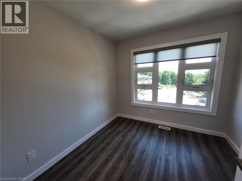 Unfurnished room with baseboards and dark wood-style floors - 118 Gravel Ridge Trail Unit# D16, Kitchener, ON - Indoor Photo Showing Other Room